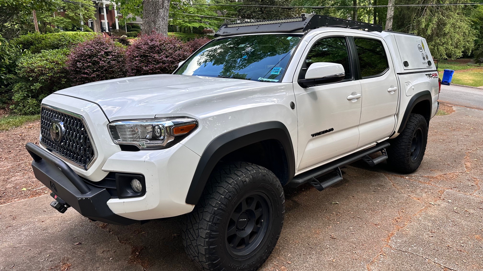 2019 Toyota Tacoma TRD 4x4 in white, parked in a driveway, with a Smartcap canopy, Prinsu cab rack with LED light bar, and roof-mounted antennas.